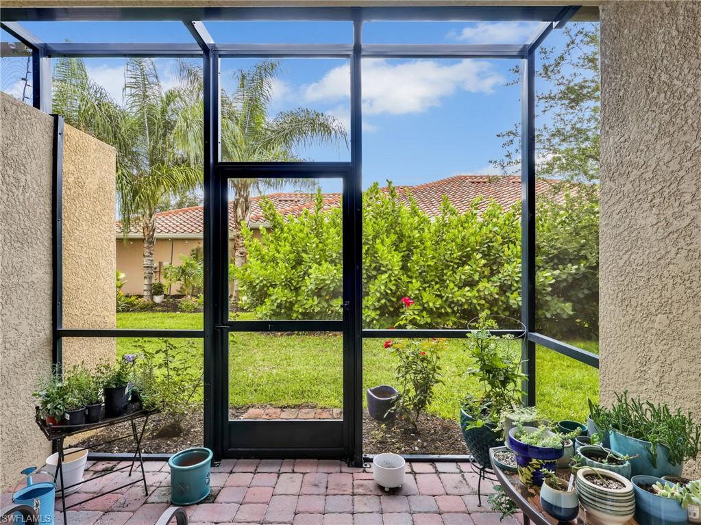 Screened patio featuring a durable brick paver surface, textured exterior walls, and direct access to a landscaped yard with mature plantings
