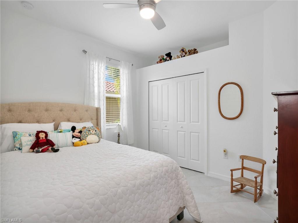 Bright room featuring light-colored flooring, a window with horizontal blinds, and bi-fold closet doors