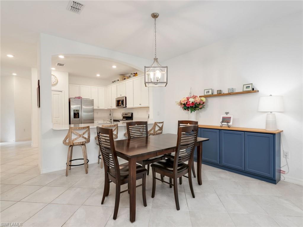 Dining area featuring light tile flooring and a contemporary chandelier