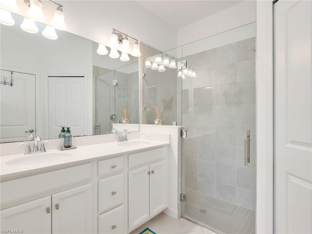 Spacious bathroom featuring a dual vanity with white cabinetry and a light-colored countertop