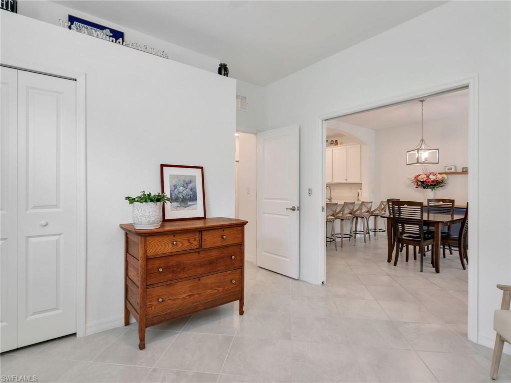 Light gray tiled flooring extends throughout this interior space, featuring a white bi-fold closet door and white walls