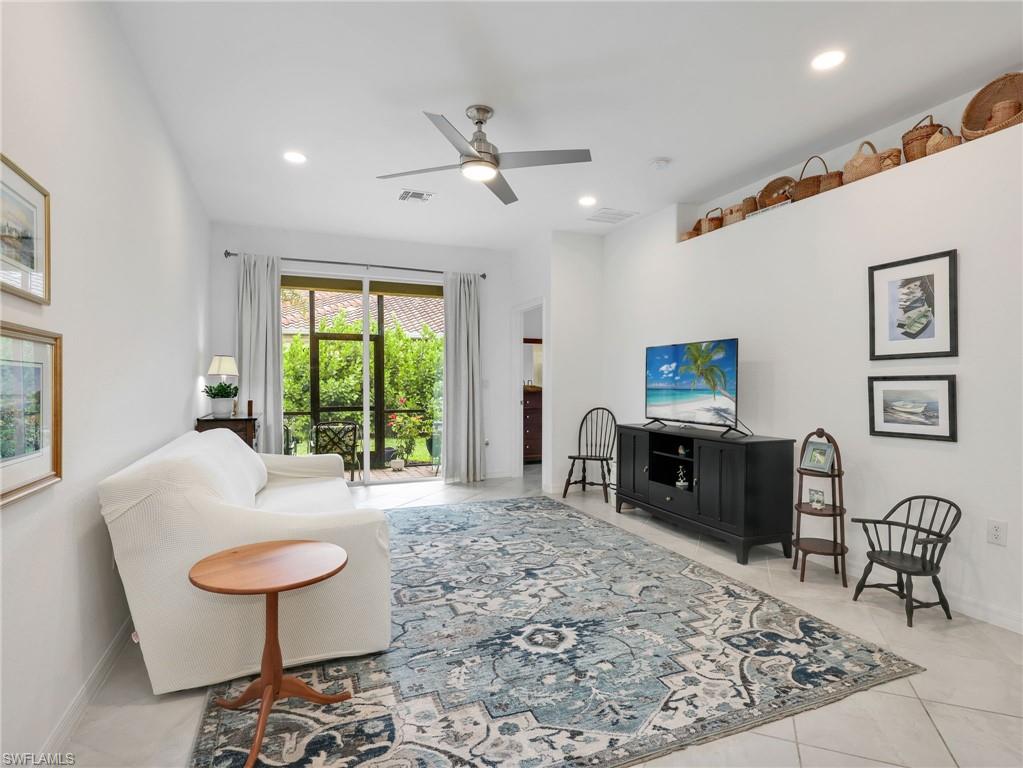 Bright living area featuring high ceilings, recessed lighting, and tile flooring