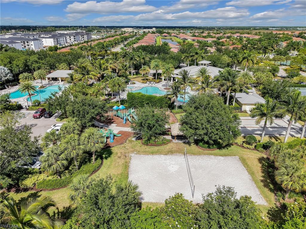 Expansive community amenities including multiple swimming pools, a sand volleyball court, and a dedicated playground area