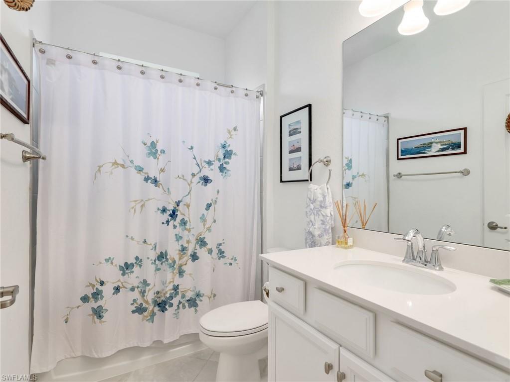 Bathroom featuring a white vanity with an integrated sink, polished chrome faucet, and a large wall-mounted mirror