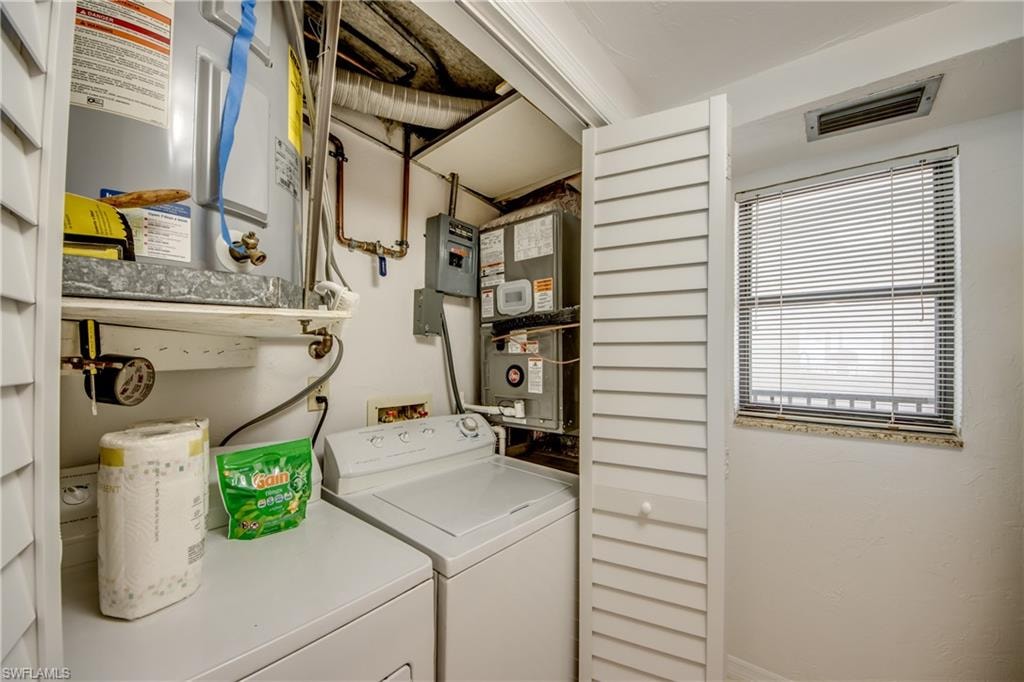 Dedicated utility space featuring laundry appliances, a hot water heater, and an HVAC unit