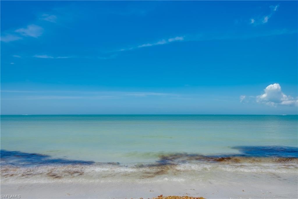 Expansive blue sky over calm, clear turquoise waters