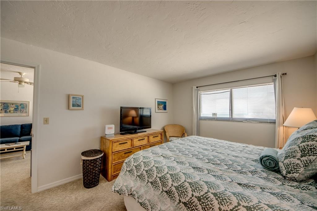 Carpeted bedroom with a window featuring horizontal blinds