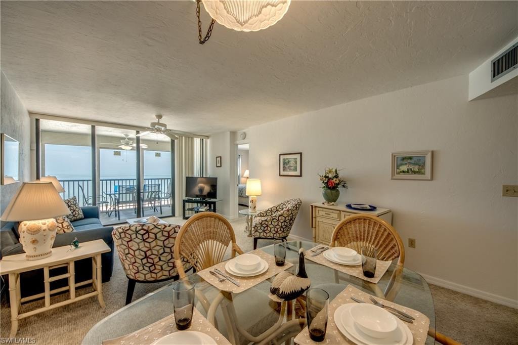 Open-concept living area with a glass dining table and direct balcony access