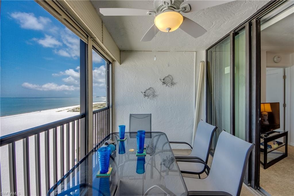 Screened balcony with panoramic white sand beach and ocean scenery