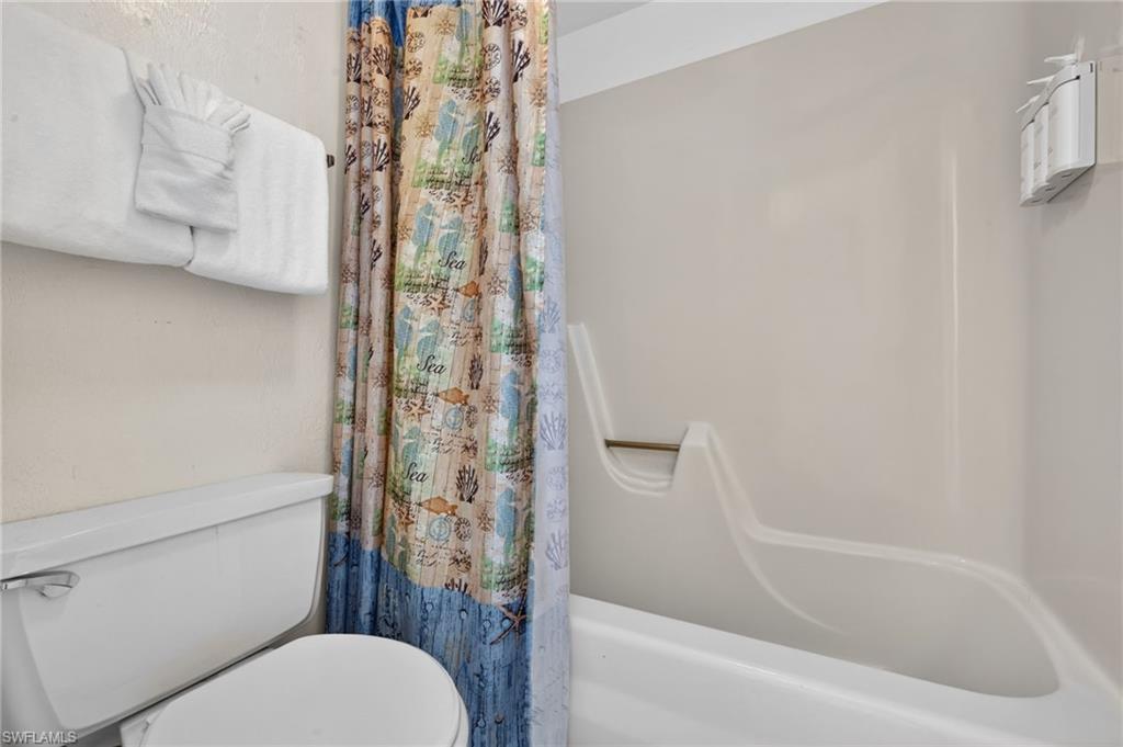 White fiberglass bathtub and shower surround with an integrated grab bar