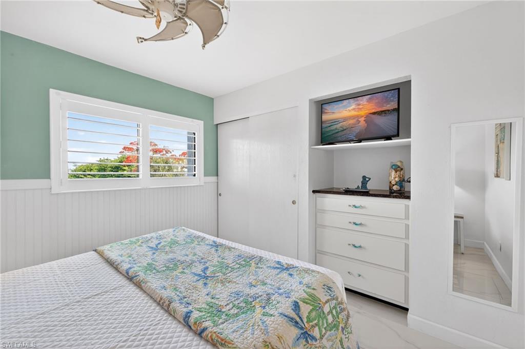 Built-in dresser with a dark countertop and integrated shelving, featuring a mounted screen