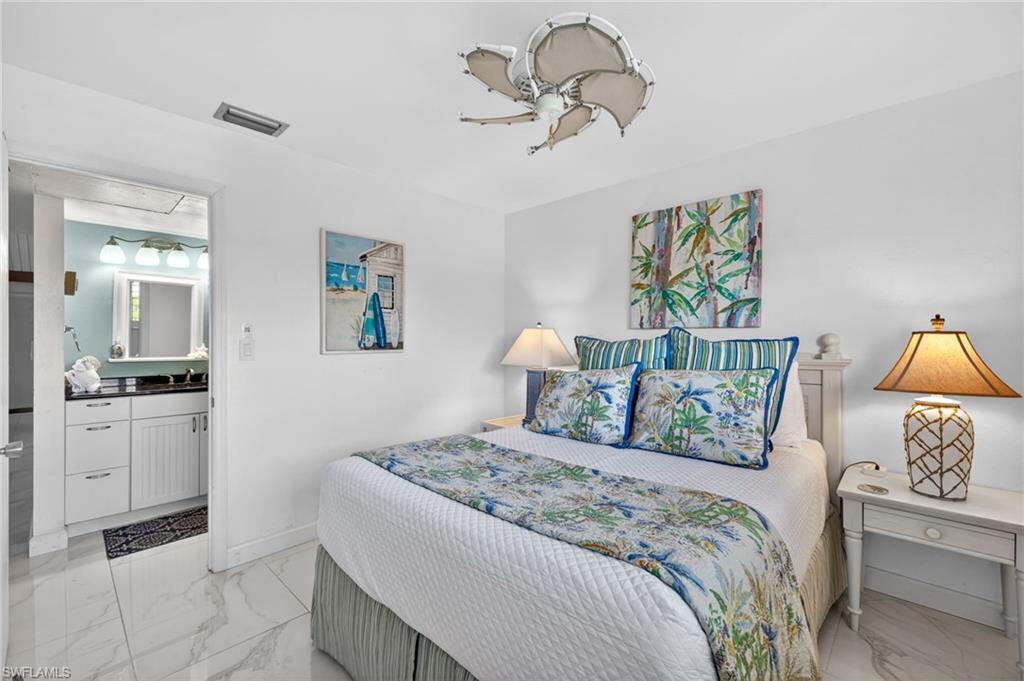 Bedroom featuring white tile flooring, a ceiling fan, and direct access to a bathroom
