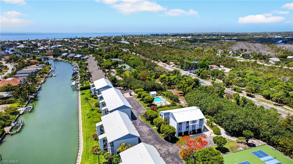 Waterfront community featuring multi-story residences, a private pool, and tennis courts