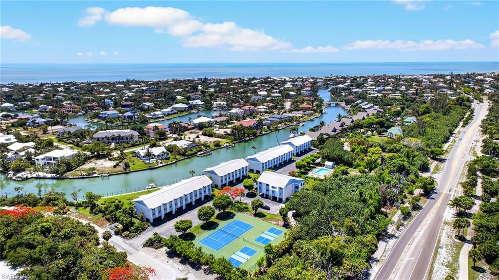 Aerial perspective showcasing coastal properties with canal access, tennis courts, and proximity to the Gulf of Mexico