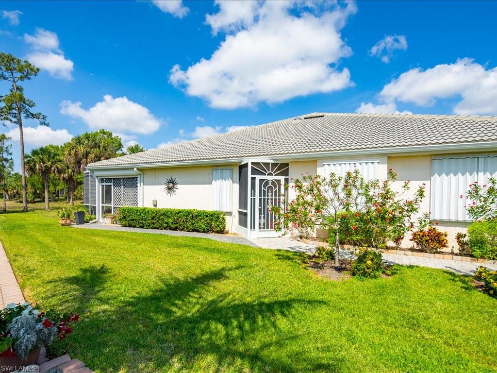 Exterior featuring a tiled roof, screened entry, and multiple windows with accordion shutters
