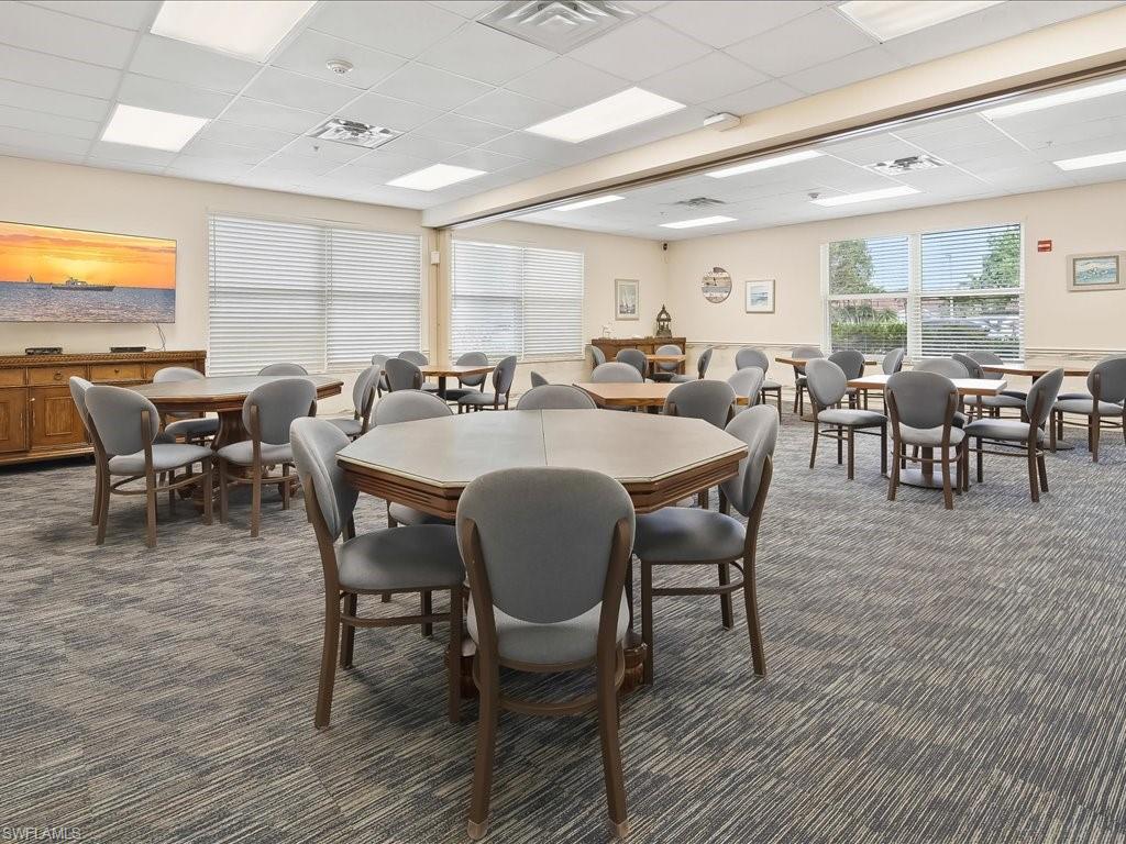 Spacious common area featuring patterned carpet flooring and ample natural light from multiple windows
