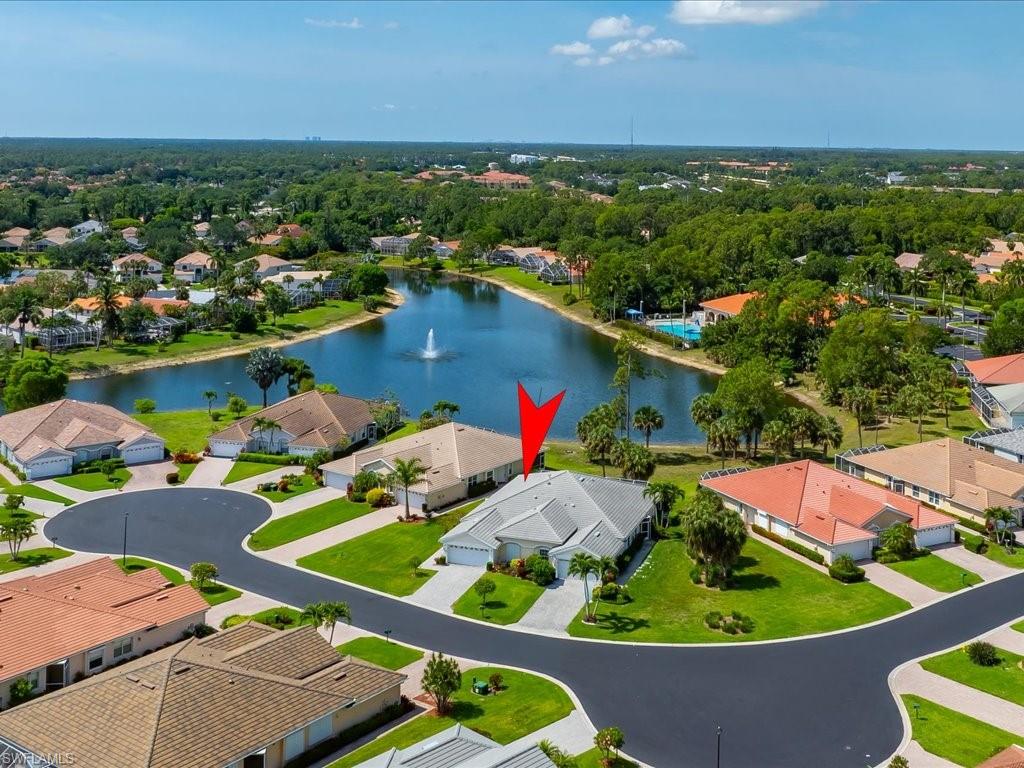 Waterfront property on a cul-de-sac featuring a paved driveway, two-car garage, and mature landscaping
