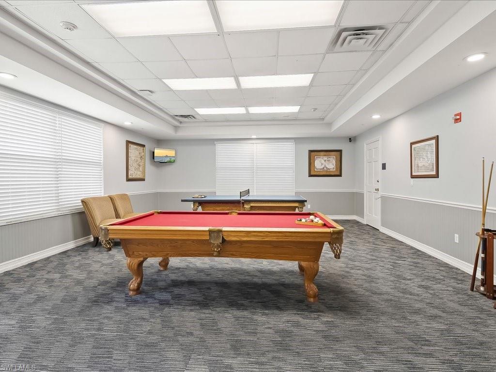 Recreational room featuring patterned carpet flooring, recessed lighting, and a white paneled ceiling