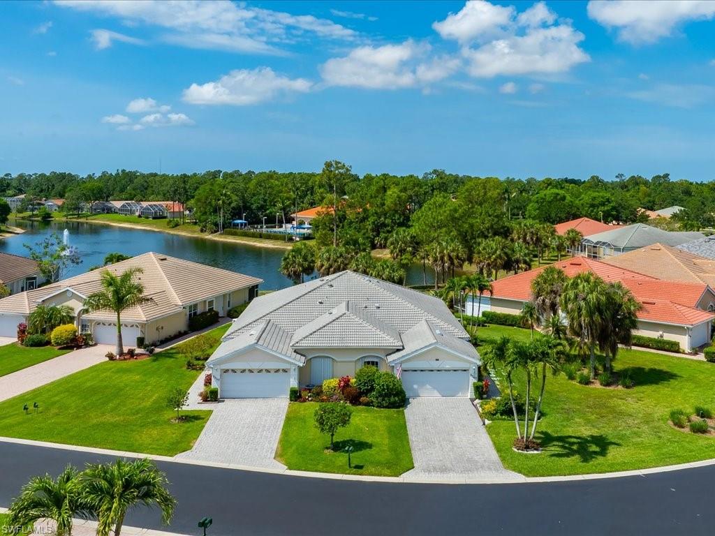 Spacious property featuring two separate driveways, two distinct garage entrances, and a neutral-toned exterior with mature landscaping