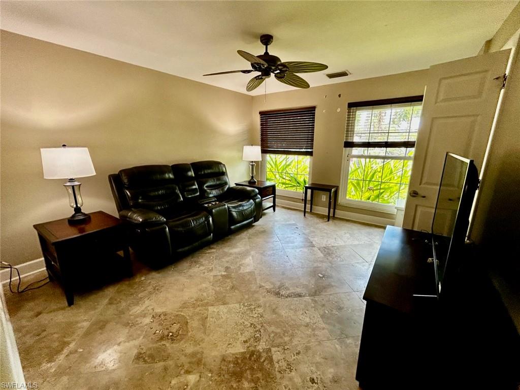 Spacious room featuring tile flooring, neutral wall tones, and two windows with blinds