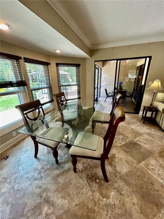 Spacious room featuring large format stone tile flooring and crown molding
