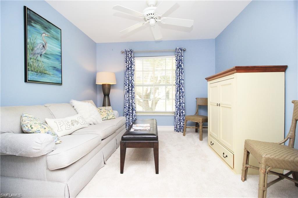 Carpeted living room with ceiling fan