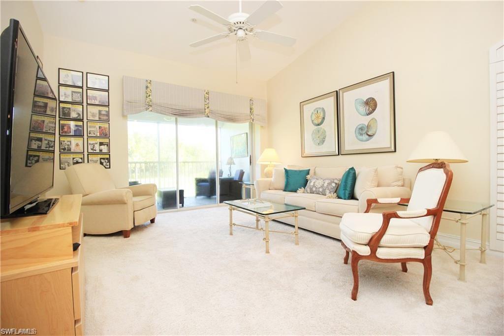 Carpeted living room with ceiling fan