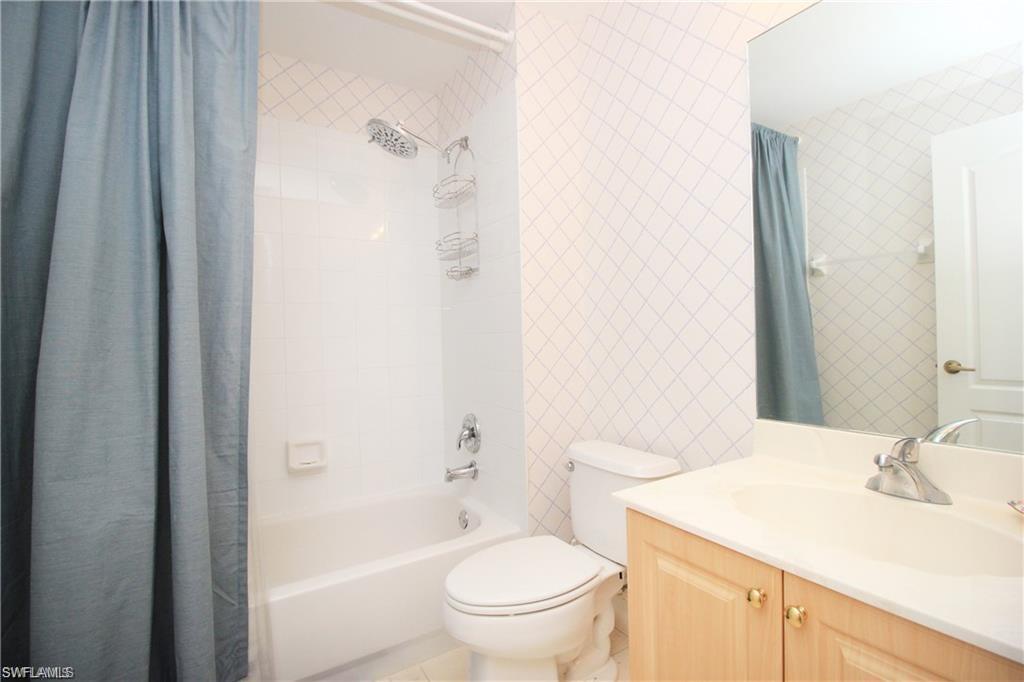 Full bathroom with vanity, toilet, and shower / bath combination with curtain