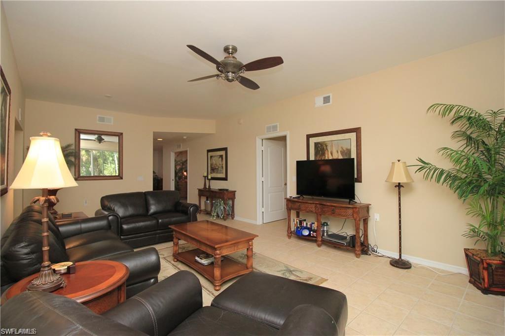 Living room with ceiling fan and light tile patterned floors