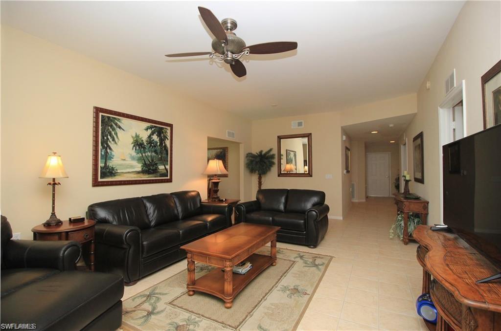 Living room with ceiling fan and light tile patterned floors