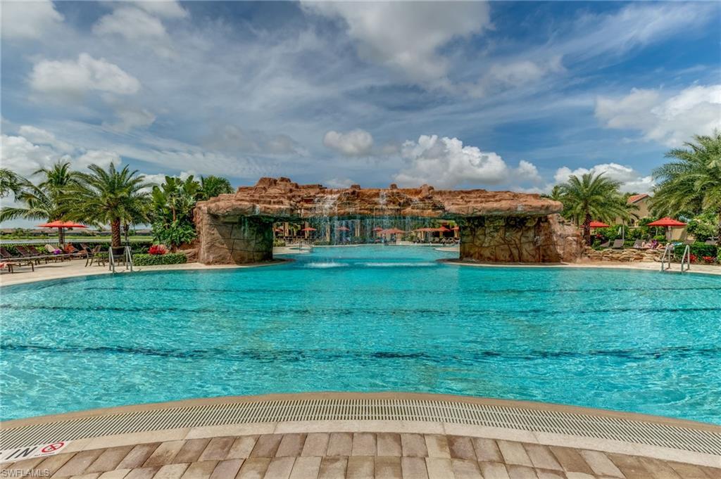 Expansive swimming pool featuring a rock-grotto waterfall structure