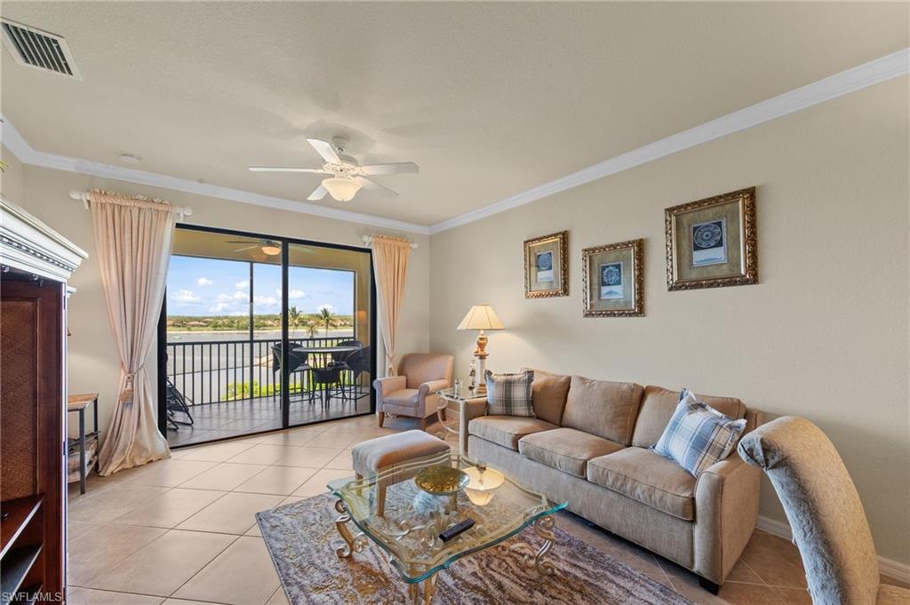 Living area featuring large format tile flooring and crown molding