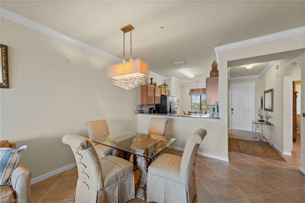 Dining area featuring a contemporary chandelier, tile flooring, and crown molding