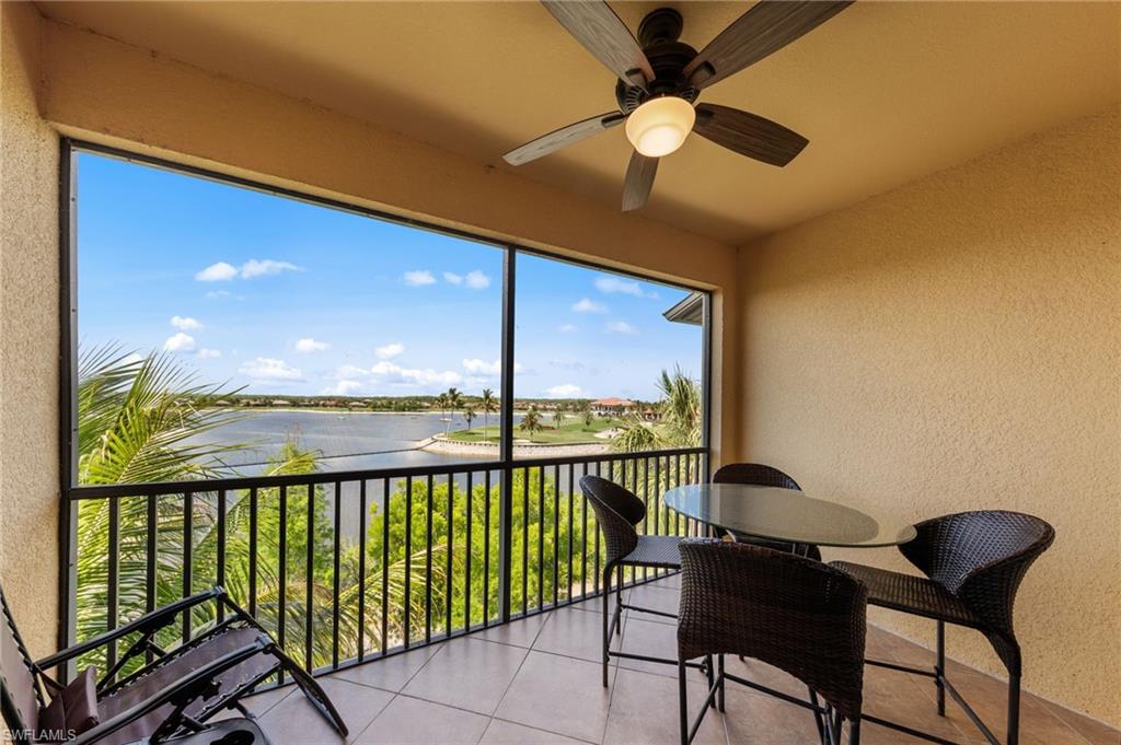 Screened balcony featuring a ceiling fan with integrated lighting, textured walls, and tile flooring