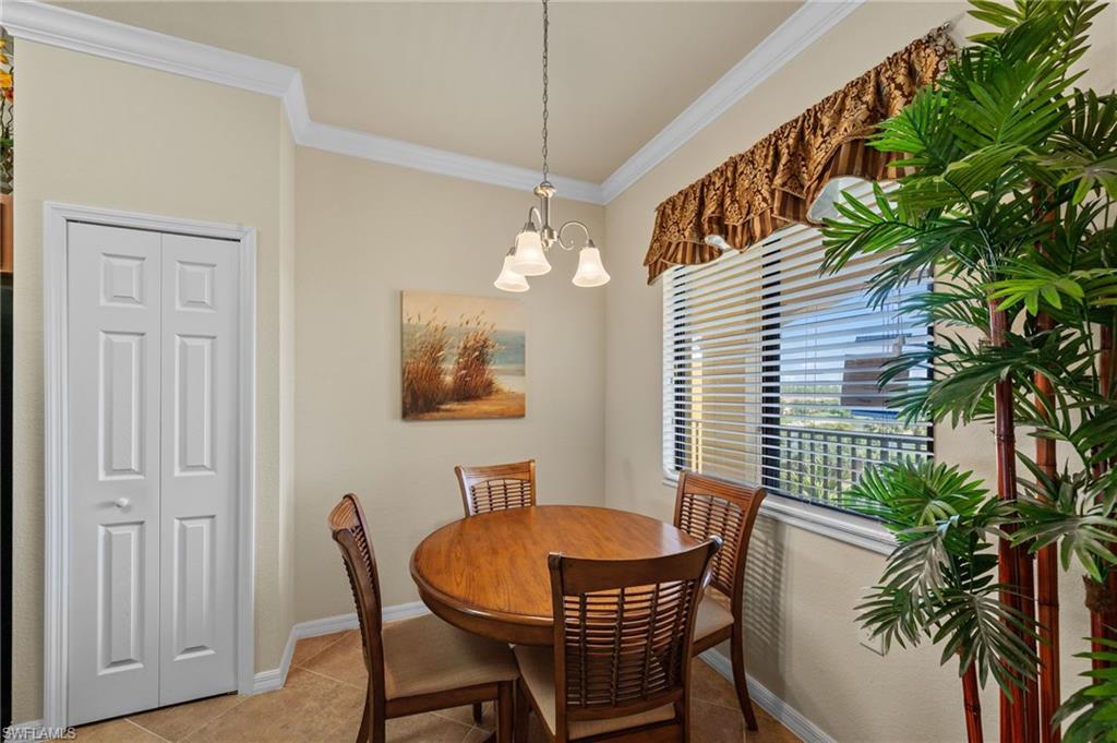 Dining area featuring crown molding, a window with horizontal blinds, and a multi-light pendant fixture
