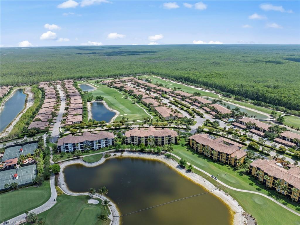 Expansive community featuring multiple residential buildings, golf course, and water features