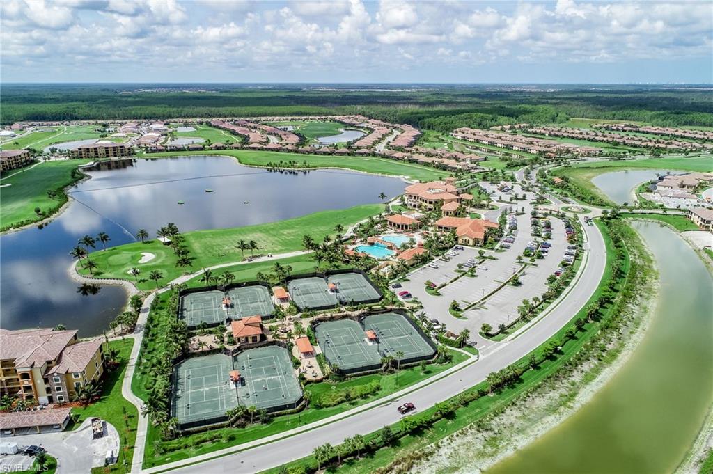 Expansive golf course community featuring multiple tennis courts, a swimming pool, and a large lake surrounded by residential properties and green spaces