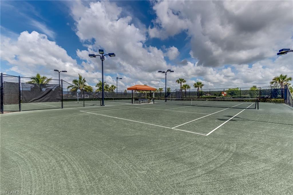 Tennis courts featuring a hard surface, surrounding perimeter fencing, and integrated lighting