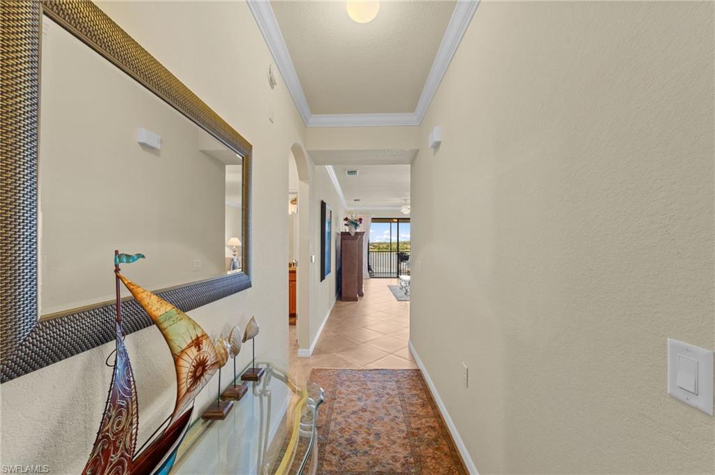 Hallway featuring neutral wall tones, crown molding, and recessed lighting