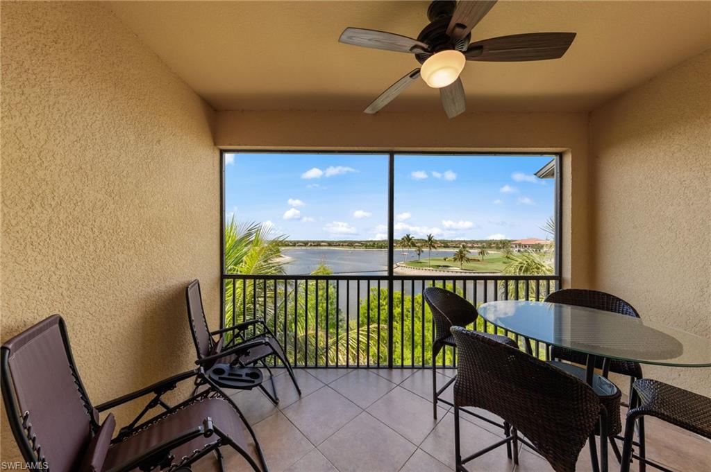 Screened balcony featuring a ceiling fan with integrated lighting, textured walls, and tile flooring