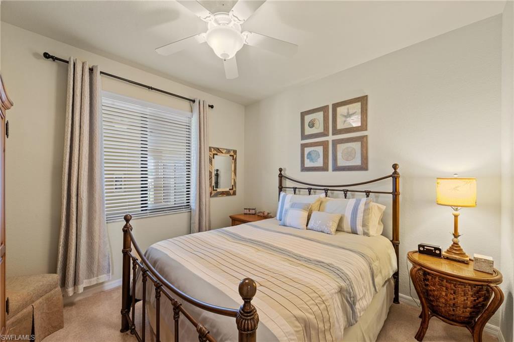 Bedroom featuring a ceiling fan with integrated lighting, a window with horizontal blinds and drapes, and neutral wall tones