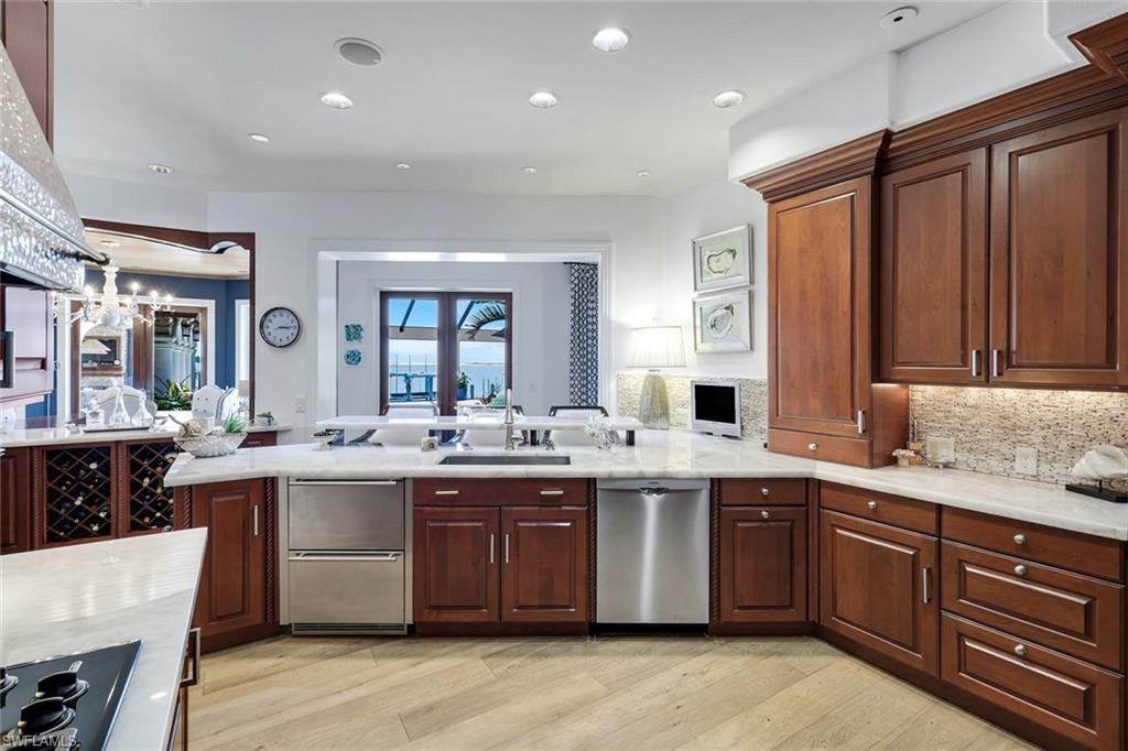 Gourmet kitchen featuring rich wood cabinetry, integrated wine storage, stainless steel appliances, and light-toned countertops