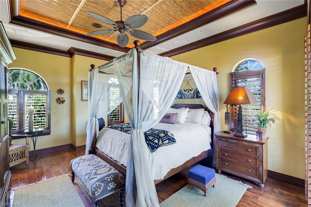 Wood-finish flooring, a textured ceiling with a built-in ceiling fan, and crown molding define this space