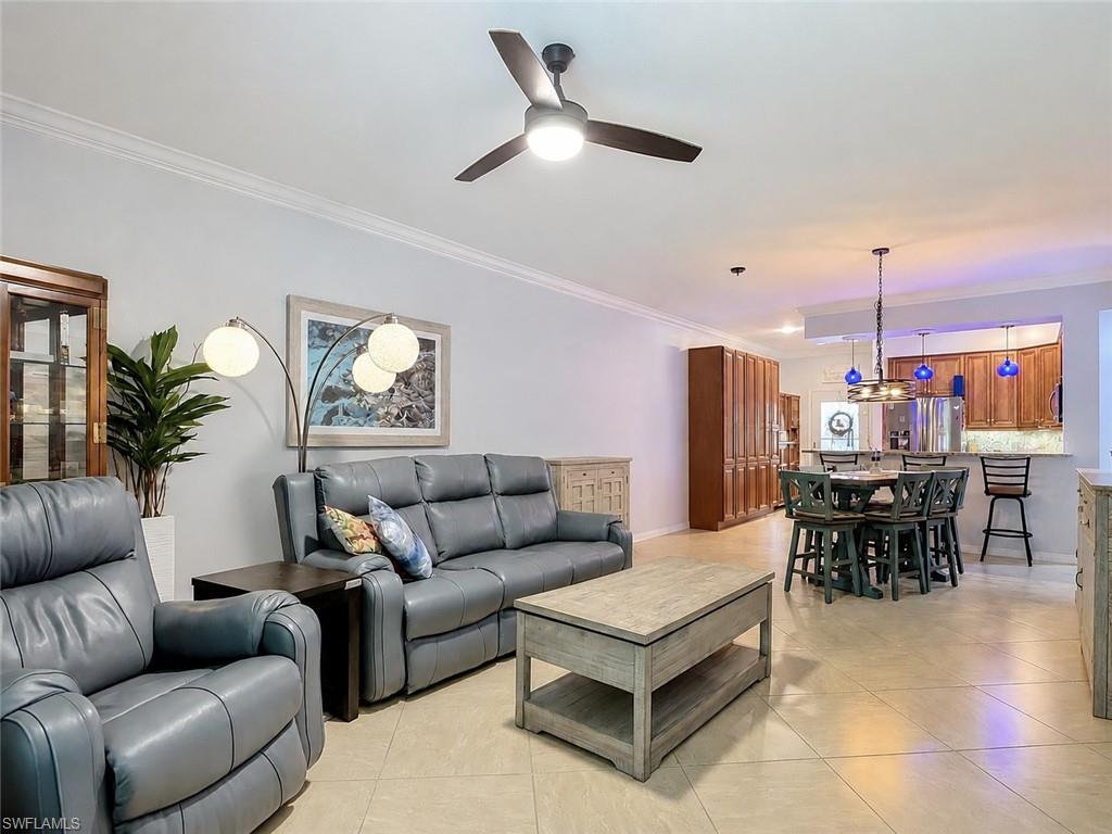 Open concept living area featuring tile flooring, crown molding, a ceiling fan, and recessed lighting