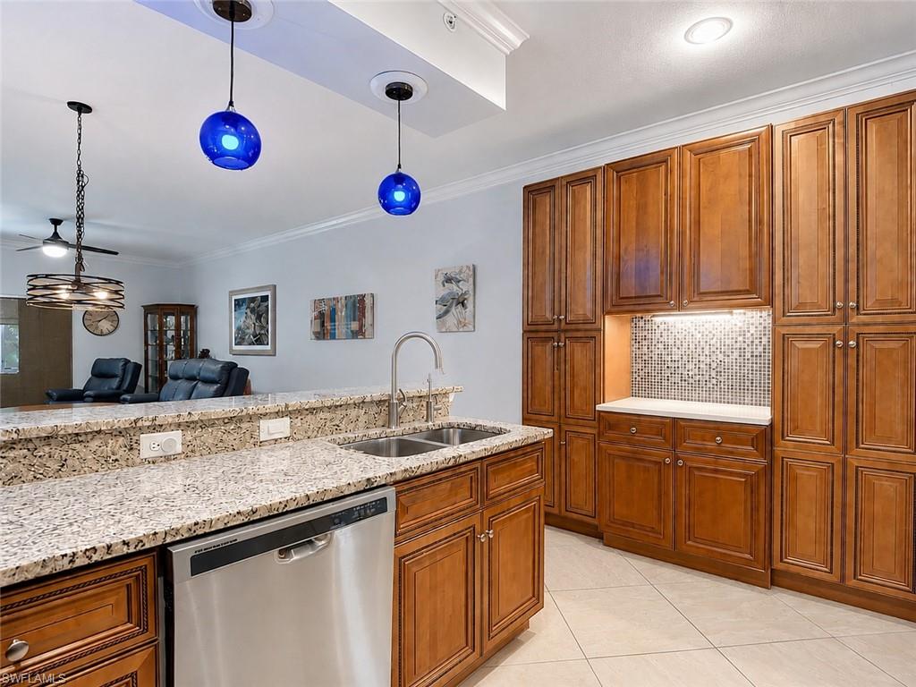 Kitchen featuring granite countertops, stainless steel dishwasher, and a dual basin sink with a gooseneck faucet