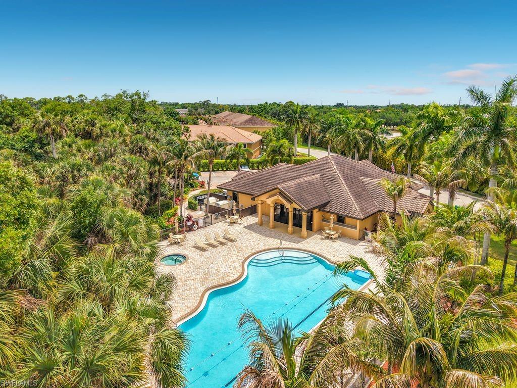 Resort-style pool area featuring a freeform swimming pool, integrated spa, and extensive paver decking