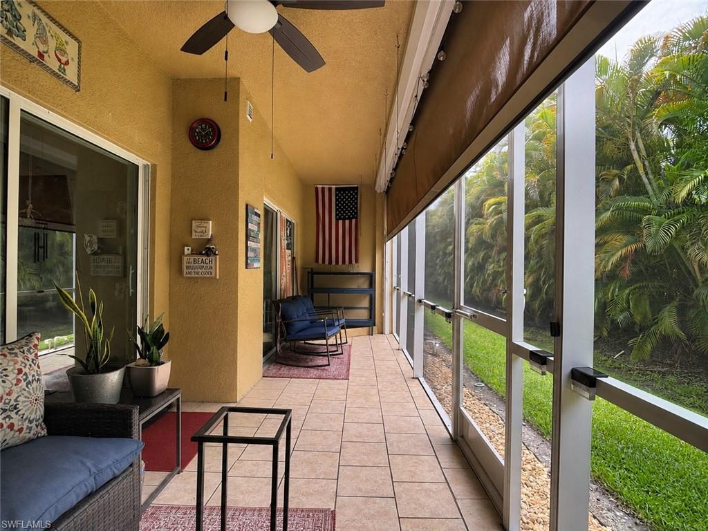 Private View. Screened-in outdoor living space featuring ceramic tile flooring, a ceiling fan, and sliding glass doors, Retractable Hurricane Shades.