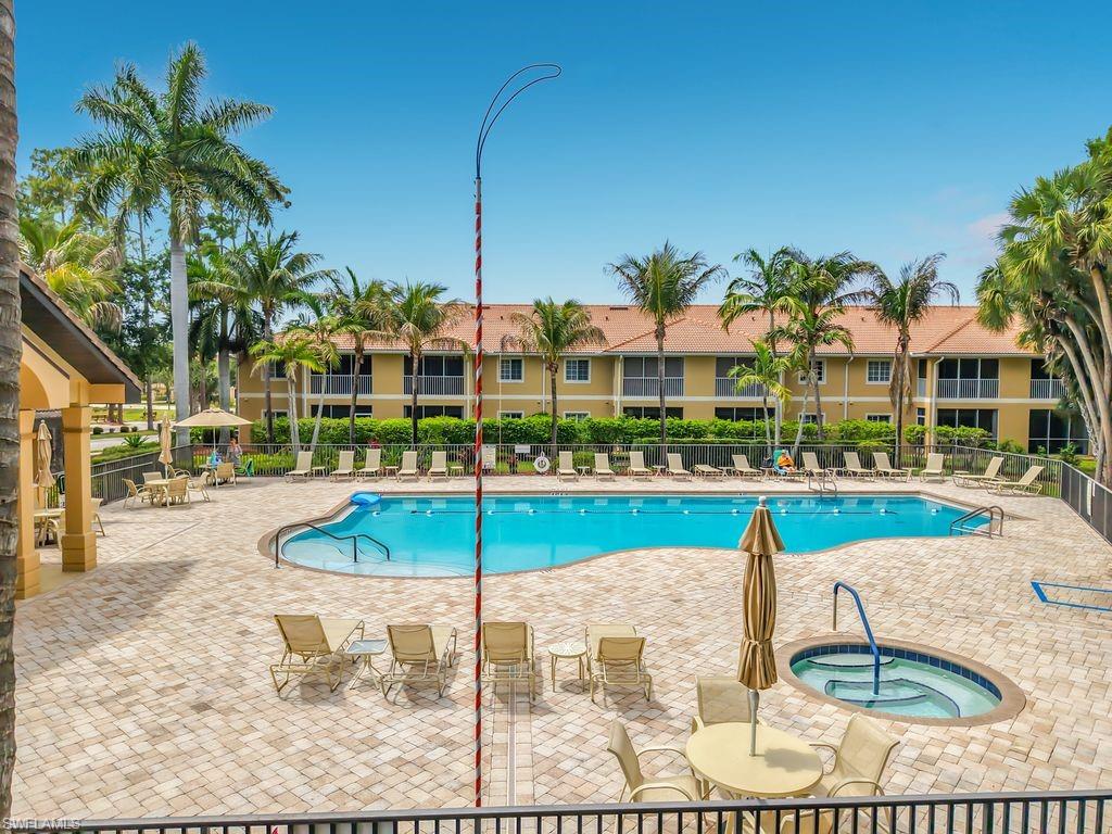 Resort-style pool area featuring a freeform swimming pool, integrated spa, and extensive paver decking
