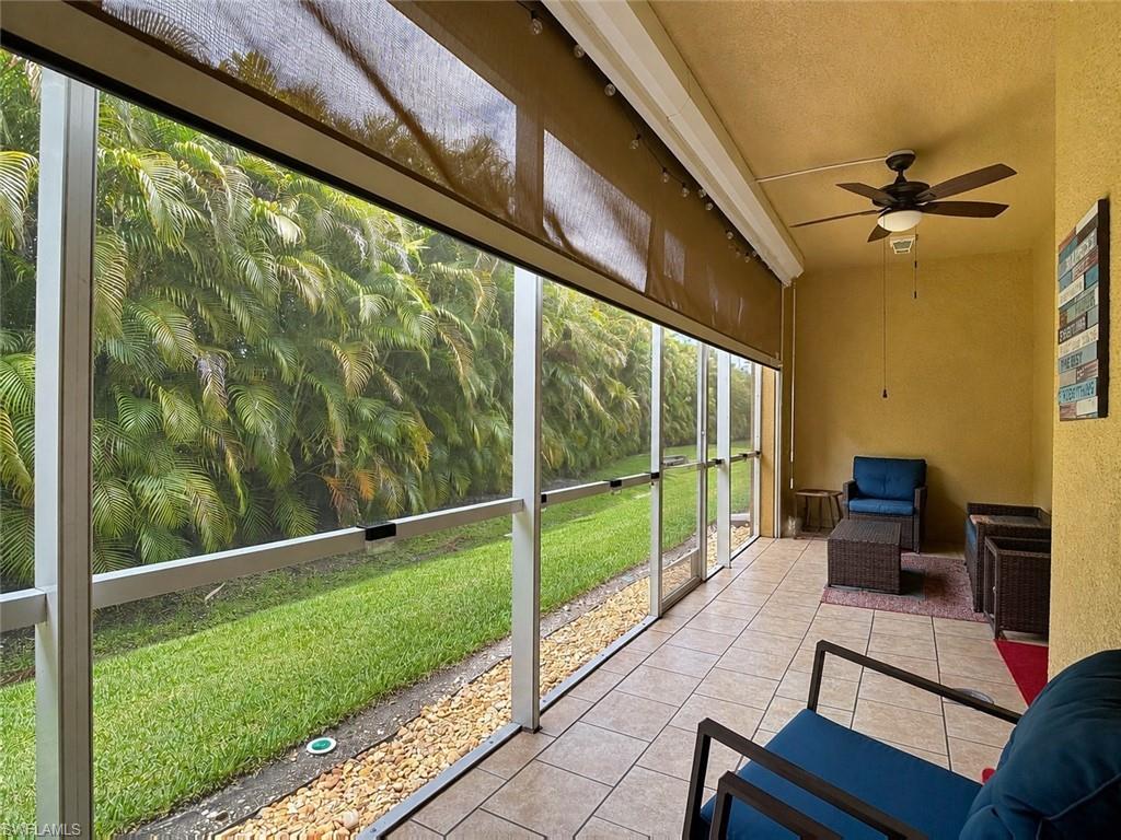 Screened outdoor living area featuring tile flooring, a ceiling fan, and Hurricane Shades