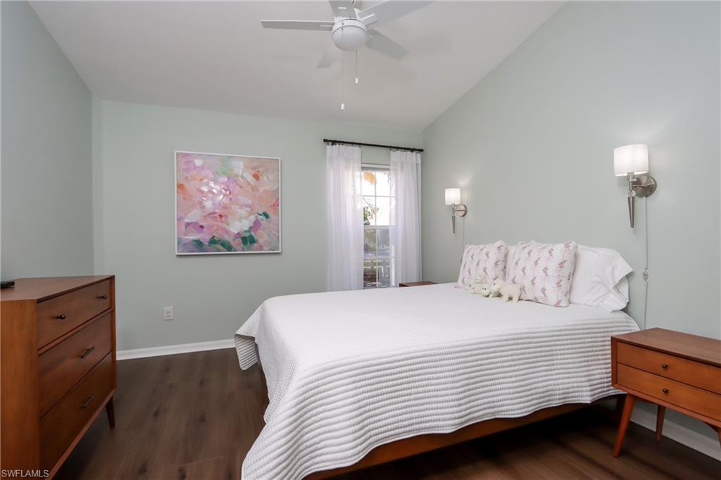 Bedroom with lofted ceiling, dark wood-style flooring, and ceiling fan